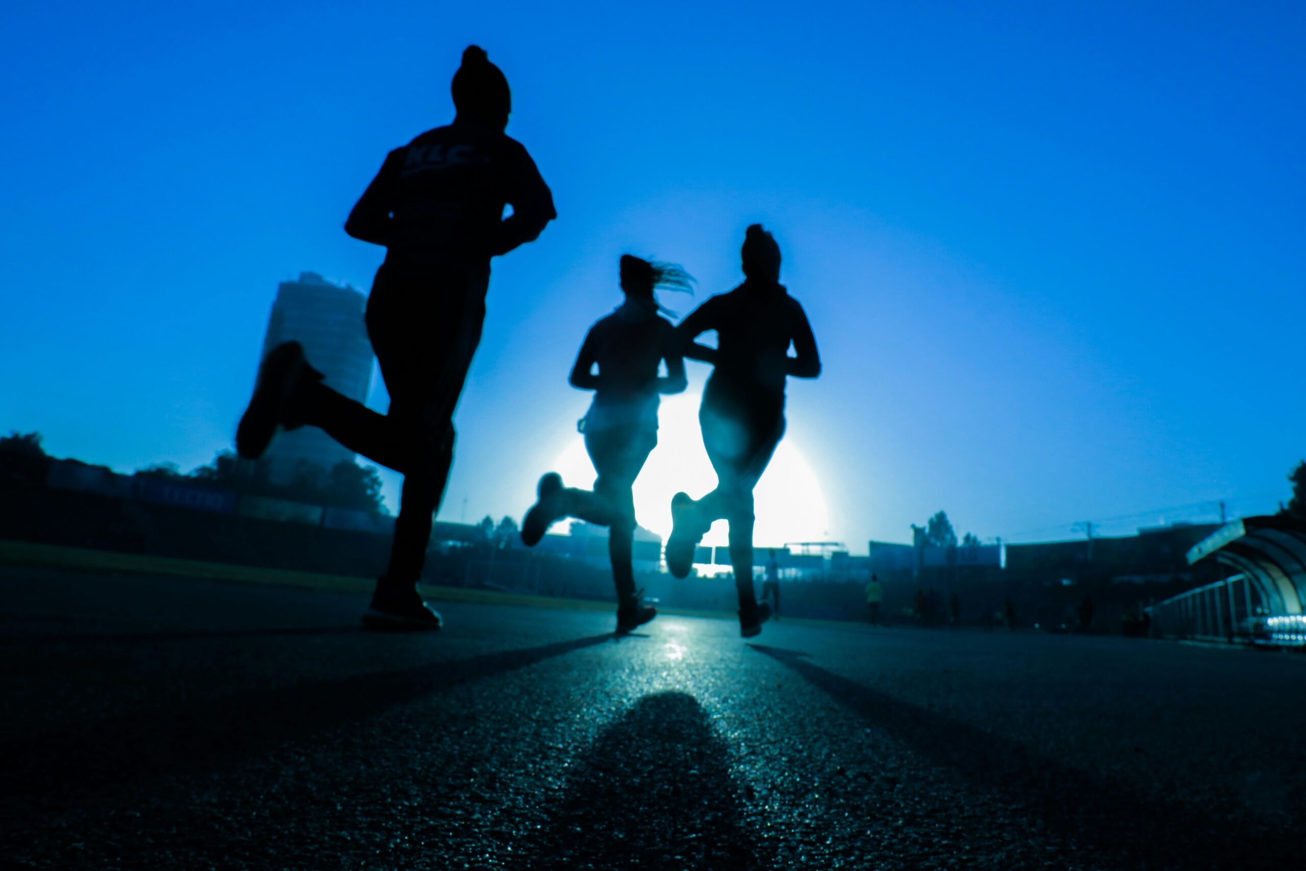 Silhouetten van lopers tijdens een hardlooptraining in de vroege ochtend
